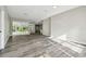 Bright living room with gray wood floors and sliding glass doors leading to the outdoors at 4227 Sandy Shores Dr, Lutz, FL 33558