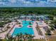 Aerial view showcases a resort-style community pool with slides, lounge chairs, and mature landscaping at 4227 Sandy Shores Dr, Lutz, FL 33558