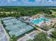 Aerial view of tennis courts, swimming pools, playground, and lush greenery, offering recreational opportunities at 4227 Sandy Shores Dr, Lutz, FL 33558