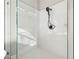 Modern shower featuring white tile, glass enclosure, and a sleek matte black shower head at 4227 Sandy Shores Dr, Lutz, FL 33558