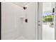 Sleek shower with white tile, modern fixtures, and an outdoor door to a screened patio, blending indoor/outdoor living at 4227 Sandy Shores Dr, Lutz, FL 33558
