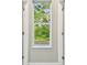 Hallway window view of trees between two doors and white trim at 4227 Sandy Shores Dr, Lutz, FL 33558