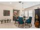 Inviting dining room with round table, blue chairs, modern chandelier, and elegant decor at 4329 Barletta Ct, Wesley Chapel, FL 33543
