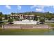 View of The Club At Estancia exterior featuring manicured landscaping, palm trees and pond at 4329 Barletta Ct, Wesley Chapel, FL 33543