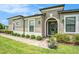 Beautiful home with a walkway, arched entrance, green door, and lush landscaping at 4329 Barletta Ct, Wesley Chapel, FL 33543