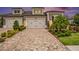 Beautiful home exterior with brick driveway, manicured landscaping, and a two-car garage at 4329 Barletta Ct, Wesley Chapel, FL 33543