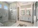 This bathroom features double sinks, white cabinets and a glass-enclosed shower at 4329 Barletta Ct, Wesley Chapel, FL 33543
