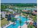 Aerial view of a luxurious pool area including water slide, tennis court and lounge chairs near a lake at 4329 Barletta Ct, Wesley Chapel, FL 33543