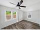 Bright bedroom with wood-look floors, a ceiling fan, and three sunny windows at 4727 17Th S Ave, St Petersburg, FL 33711