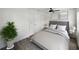 A simplistic bedroom with a ceiling fan and art hanging above a tufted headboard at 4727 17Th S Ave, St Petersburg, FL 33711