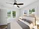 Bright bedroom with ceiling fan, features an exterior view through three windows, and hardwood flooring at 4727 17Th S Ave, St Petersburg, FL 33711