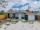 Charming single-story home featuring a blue exterior, yellow door, and a gravel driveway at 4727 17Th S Ave, St Petersburg, FL 33711