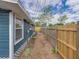 Side yard showing blue home with white trim and privacy fence at 4727 17Th S Ave, St Petersburg, FL 33711
