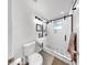 Modern bathroom featuring a walk-in shower with stylish black fixtures, a wall-mounted sink, and a contemporary toilet at 4735 W Oklahoma Ave, Tampa, FL 33616