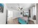 Bright bedroom with ample natural light, a twin bed, and a ceiling fan, accentuated by contemporary wood-look flooring at 4735 W Oklahoma Ave, Tampa, FL 33616