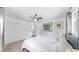 A well-lit bedroom with crisp white walls, wood floors, a ceiling fan, and a comfortable queen-size bed at 4735 W Oklahoma Ave, Tampa, FL 33616