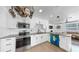 Bright kitchen features stainless steel appliances, granite countertops, white backsplash and cabinets and modern lighting at 4735 W Oklahoma Ave, Tampa, FL 33616