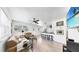 Open-concept living room features natural light, wood-look tile flooring, and kitchen with breakfast bar at 4735 W Oklahoma Ave, Tampa, FL 33616