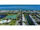 Aerial view showcasing waterfront condos, tennis courts, and a pool overlooking the ocean at 5075 Starfish Se Dr # A, St Petersburg, FL 33705