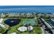 Stunning aerial view of waterfront homes, tennis courts, and a pool, set against the backdrop of a beautiful bay at 5075 Starfish Se Dr # A, St Petersburg, FL 33705