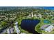 Expansive aerial shot captures homes near a serene lake and tennis court, all framed by a cityscape in the distance at 5075 Starfish Se Dr # A, St Petersburg, FL 33705