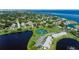 Scenic aerial view showcases waterfront homes, a tranquil lake, and a well-maintained tennis court in a lush, green setting at 5075 Starfish Se Dr # A, St Petersburg, FL 33705