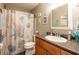 Bathroom with decorative shower curtain, wood-look flooring, and updated vanity at 5075 Starfish Se Dr # A, St Petersburg, FL 33705