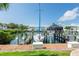 Dock view with sailboat and covered powerboat with waterfront condo in the background at 5075 Starfish Se Dr # A, St Petersburg, FL 33705