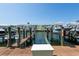 Dock view featuring boat slip with a boat lift and boats in a waterfront community at 5075 Starfish Se Dr # A, St Petersburg, FL 33705