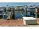 Dock view featuring boat slip with a boat lift and a storage box in a waterfront community at 5075 Starfish Se Dr # A, St Petersburg, FL 33705