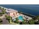 Waterfront clubhouse featuring a pier, pool, lounge chairs, and well maintained landscaping at 5075 Starfish Se Dr # A, St Petersburg, FL 33705