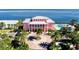 Grand pink waterfront home with a circular drive, lush landscaping, and community pool access at 5075 Starfish Se Dr # A, St Petersburg, FL 33705
