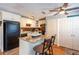 Kitchen featuring granite island with barstool seating, black appliances and wood-look flooring at 5075 Starfish Se Dr # A, St Petersburg, FL 33705