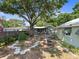 Spacious backyard with lush garden, stone walkway, mature trees, with several detached buildings at 544 80Th N Ave, St Petersburg, FL 33702