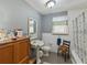 Full bathroom with pedestal sink, tiled shower, and vintage wood accents at 544 80Th N Ave, St Petersburg, FL 33702