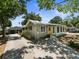 Charming single-story home with a yellow front door, lush landscaping, and a detached garage at 544 80Th N Ave, St Petersburg, FL 33702
