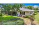 Well-maintained backyard with lush green lawn, mature trees, and a screened-in porch at 5456 Fairway Bend Dr, Sarasota, FL 34243