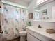 Bright bathroom boasts a stylish vanity with marble countertops and modern fixtures, complemented by a seashell-themed shower curtain at 5456 Fairway Bend Dr, Sarasota, FL 34243