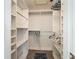 Walk-in closet has built-in shelving and hanging rods, and a blue rug on the floor at 5456 Fairway Bend Dr, Sarasota, FL 34243