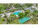 Community pool and shuffleboard surrounded by tropical trees and manicured landscaping at 5456 Fairway Bend Dr, Sarasota, FL 34243