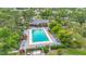 Aerial view of a well-maintained community pool area with ample seating and lush landscaping at 5456 Fairway Bend Dr, Sarasota, FL 34243