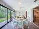 Bright dining area featuring a white table set, with natural light streaming through sliding glass doors to a garden view at 5456 Fairway Bend Dr, Sarasota, FL 34243