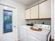 Bright laundry room with appliances and storage, conveniently located near the exit door at 5456 Fairway Bend Dr, Sarasota, FL 34243