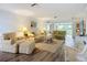 Inviting living area with wood floors, striped furniture, and access to outdoor spaces at 5456 Fairway Bend Dr, Sarasota, FL 34243