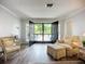 Bright living room featuring luxury vinyl floors and view to the outdoor patio at 5456 Fairway Bend Dr, Sarasota, FL 34243
