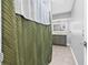 Updated bathroom with modern vanity and illuminated mirror, viewed through decorative shower curtain at 5734 20Th N Ave, St Petersburg, FL 33710