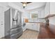 Updated kitchen with stainless steel refrigerator, white cabinets, and warm wood countertops at 5734 20Th N Ave, St Petersburg, FL 33710