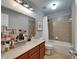 Bathroom features wood vanity, shower-tub combo, tile floors and plenty of natural light at 5914 Goldenbark Pl, Lithia, FL 33547