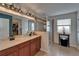 Bathroom featuring double sinks, tile flooring, glass-enclosed shower, and a linen closet at 5914 Goldenbark Pl, Lithia, FL 33547