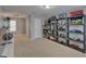 Spacious bonus room featuring neutral carpeting and ample storage space with shelving units at 5914 Goldenbark Pl, Lithia, FL 33547